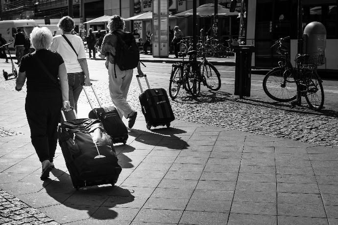 grayscale photo of man and woman walking on sidewalk